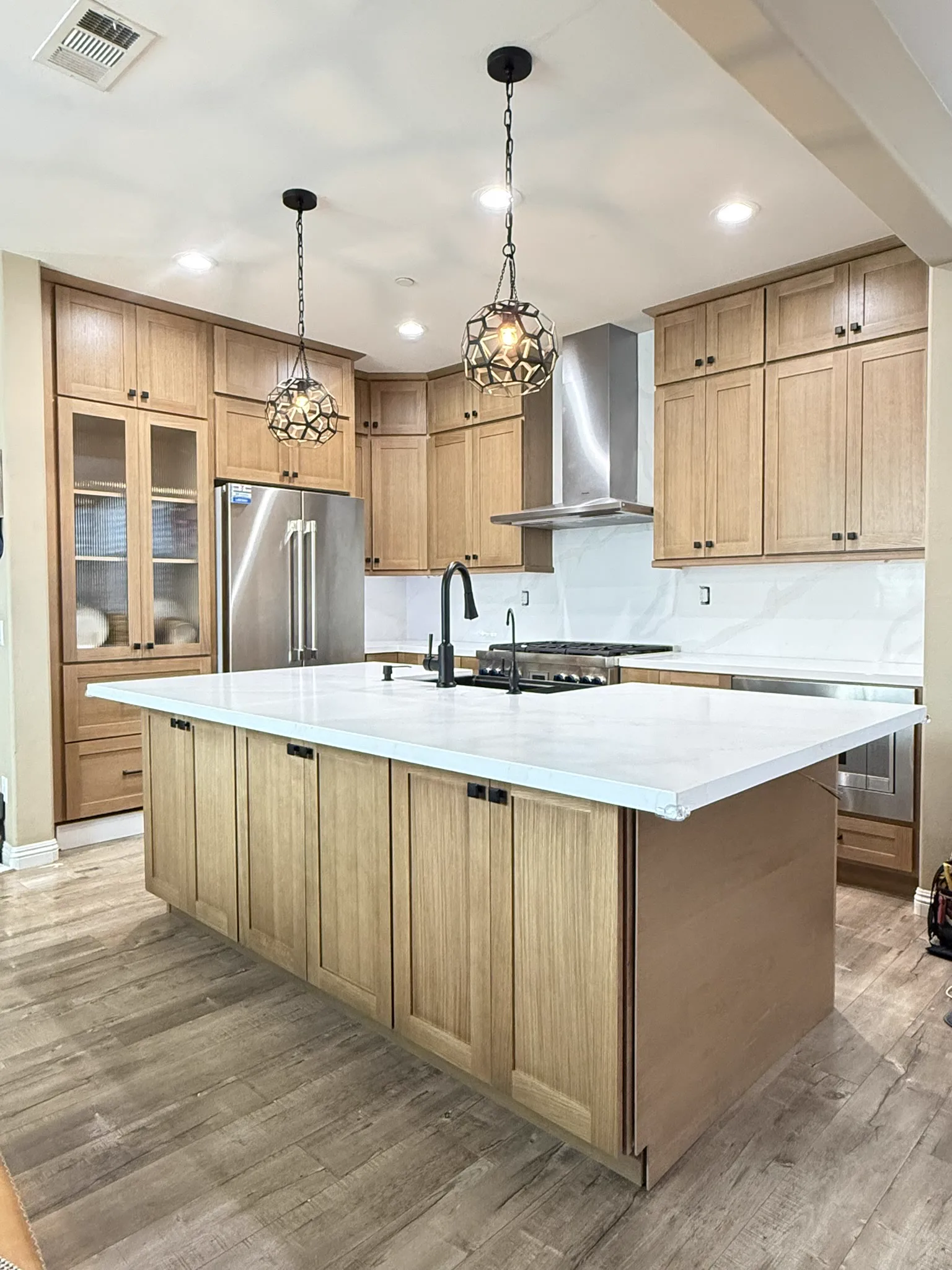 White quartz island with wood cabinets
